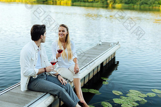 快乐的年轻夫妇坐在河边