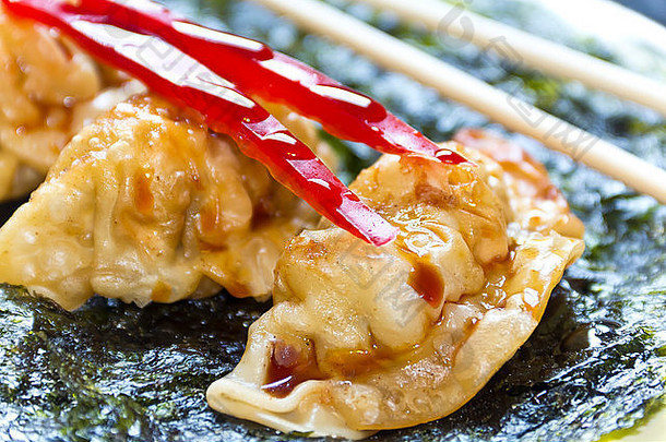 油炸日本饺子，配脆烤紫菜和红辣椒装饰