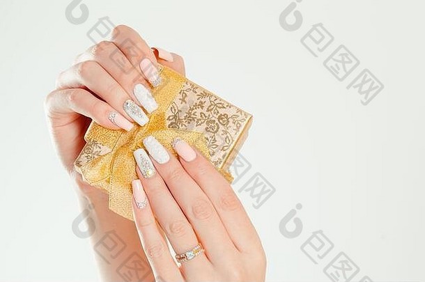 礼物盒子现代风格柔和的珊瑚粉红色的白色婚礼指甲波兰的美手持有金礼物盒子时尚的色彩斑斓的法国指甲孤立的白色