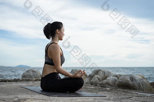 在海边的超现实主义<strong>日</strong>落中练习瑜伽的女人。健康概念和锻炼。