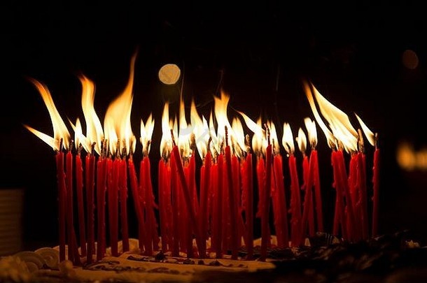 在黑暗环境中燃烧的生日蛋糕蜡烛的细节