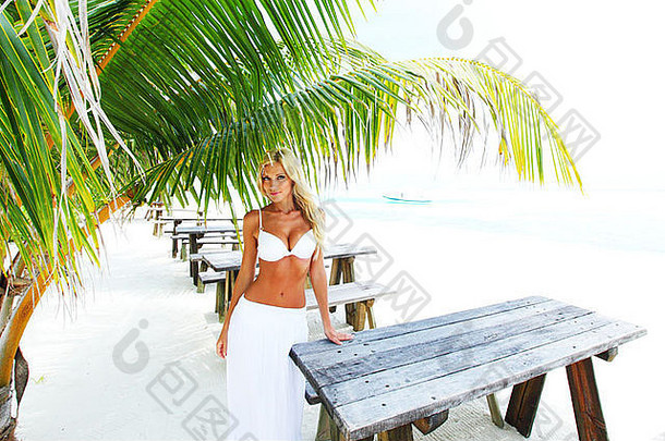 女人坐着热带咖啡馆背景棕榈树天空海