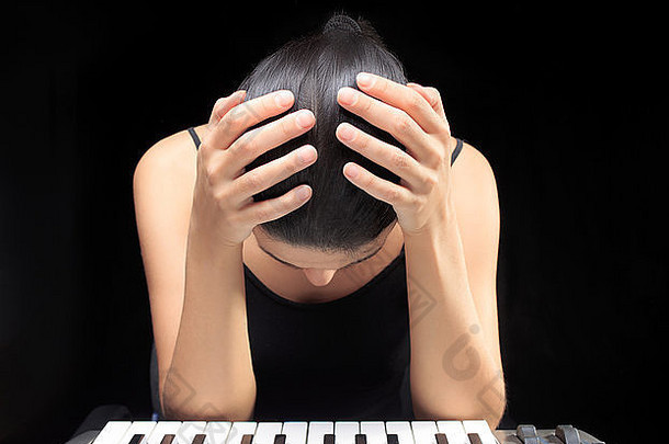 情绪化的女人在学习弹钢琴。