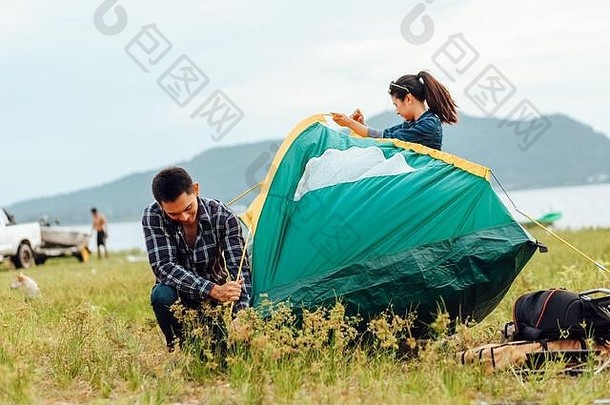 一群朋友在湖边和山后旅行和露营。
