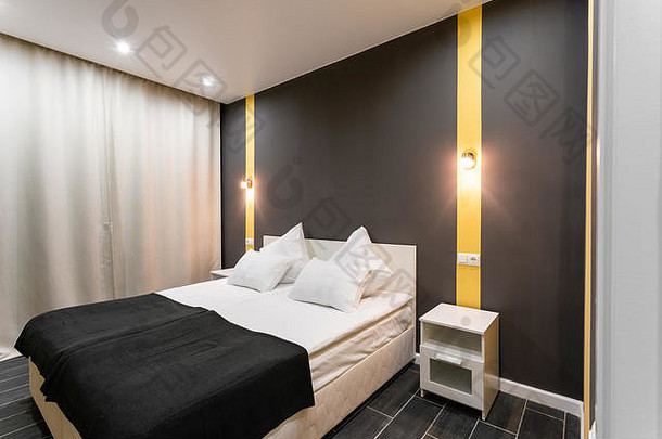 酒店<strong>标准间</strong>。带有白色枕头的现代卧室。简洁时尚的内饰。室内照明