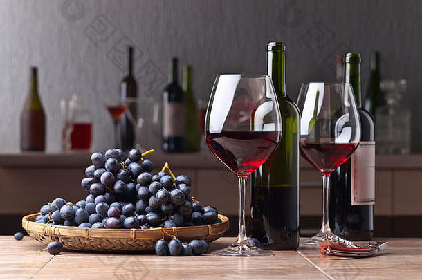 餐桌上放着一杯红酒和葡萄