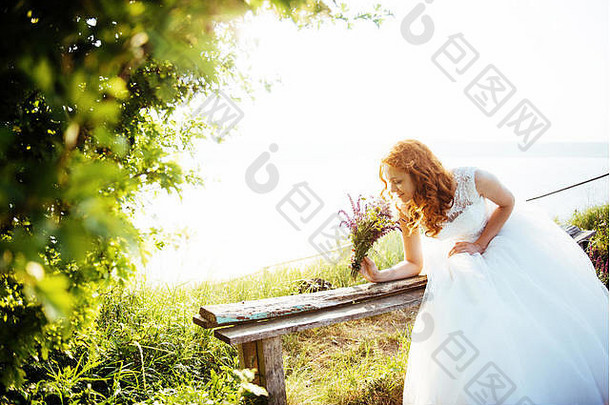 新娘在水边拿着一束花