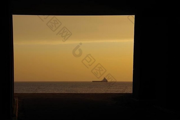 在金色的早晨，方形混凝土地下通道可以看到北海和一艘石油支援船。阿伯丁，苏格兰，英国。