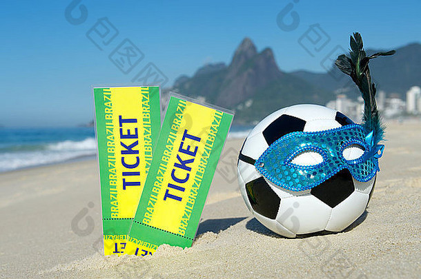 在伊帕内马海滩，巴西门票站在足球主题里约狂欢节足球旁边，戴着闪亮的面具