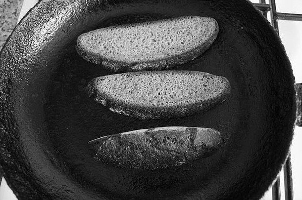 黑平底锅上的黑色干黑麦面包片，用于制作拉斯克面包