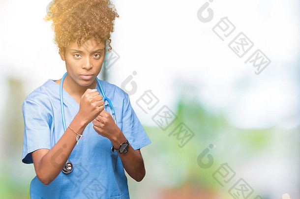 年轻的非裔美国女医生在与世隔绝的背景下准备用拳头自卫的姿势进行战斗，脸上充满愤怒和不安，害怕出现问题