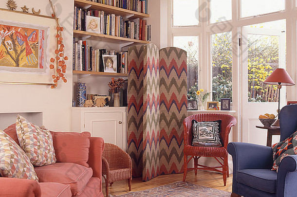 90年代的客厅里，书架旁的锯齿形折叠式屏风，有粉色沙发和落地窗