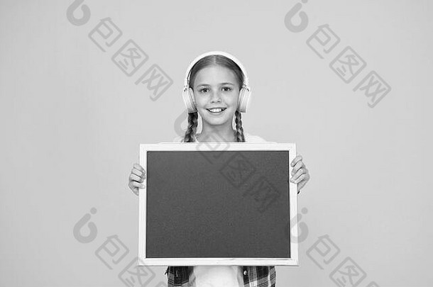 赶时髦的人女孩持有空黑板上女学生休闲风格显示信息学校市场购物音乐耳机孩子展示项目现代学校梦想大