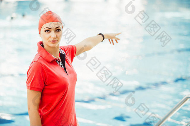 休闲中心游泳池旁带秒表和剪贴板的女教练肖像