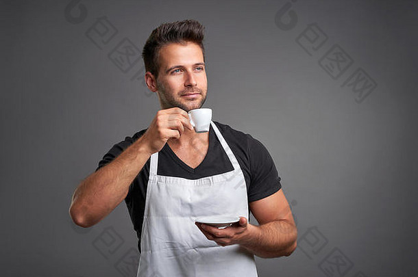 年轻的咖啡师男人。微笑享受杯咖啡