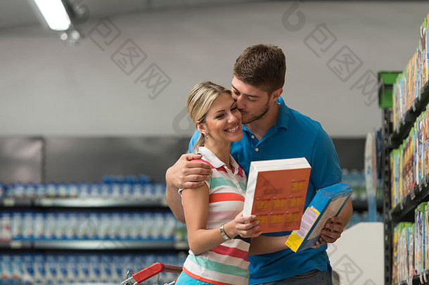 一对美丽的年轻夫妇在一家杂货店的农产品部——超市——购买早餐用的雪花