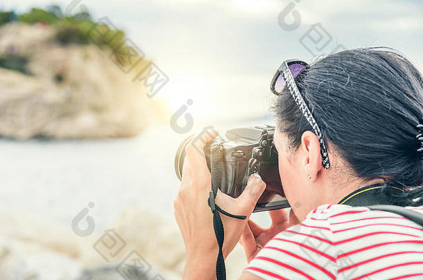 女人相机拍摄日落海海岸