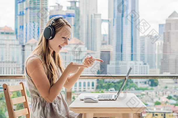 在大城市的背景下，一位年轻女子在阳台上教授<strong>外语</strong>或在互联网上学习<strong>外语</strong>。在线语言
