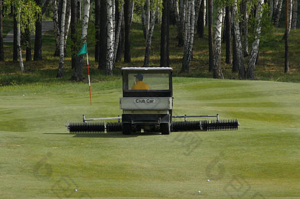 割草机在苏格兰高尔夫球场边缘的草地上工作。高尔夫草坪机