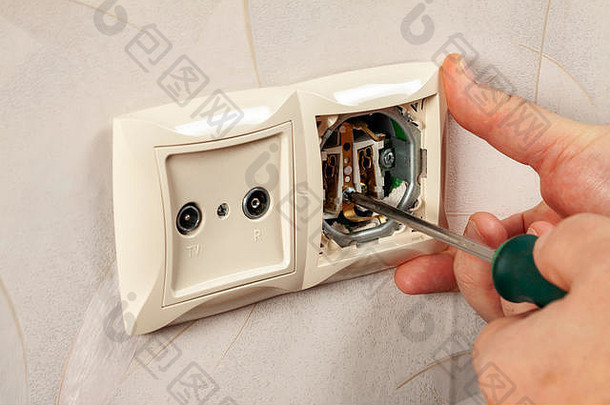 修理房子墙上的电源插座。