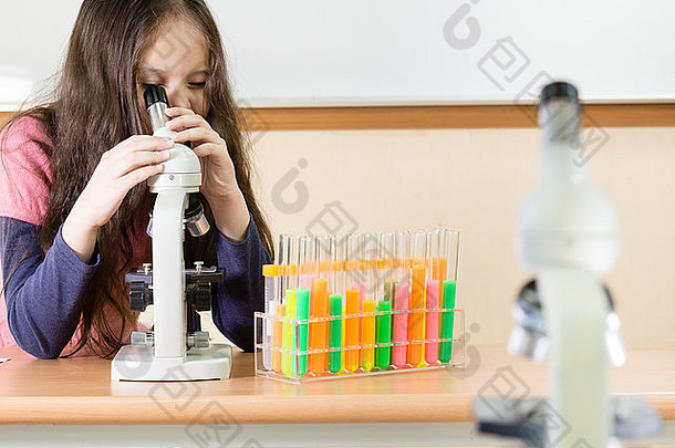 科学实验室里拿着显微镜和试管的年轻女科学家