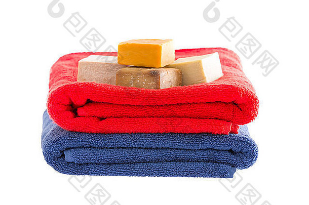 两条色彩鲜艳、柔软、蓬松的折叠棉毛巾，白色表面隔离有机草本肥皂条，营造健康的芳香b