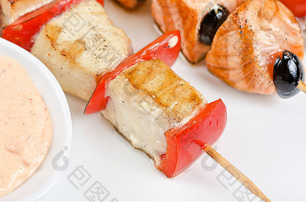 烤三文鱼和虾的特写镜头，在竹竿上放着西红柿和辣椒