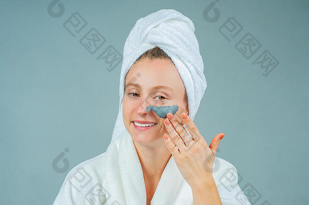 水疗泥面膜。美丽的年轻女子正在使用泥质面膜。护肤美容理念。
