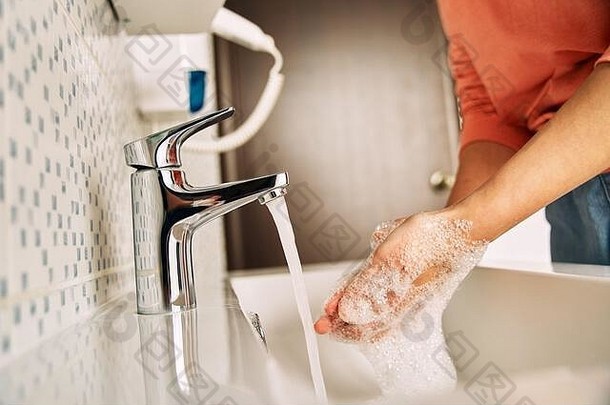 女孩用肥皂洗手以防止冠状病毒。