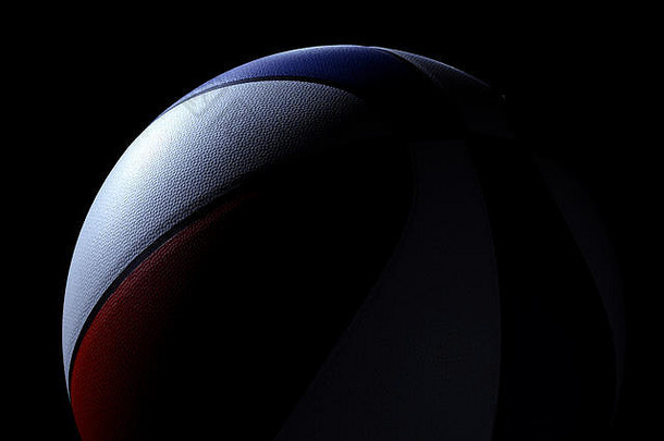 红色、白色和蓝色的单<strong>篮球</strong>正面视图，位于黑色背景上。光线直接照射在<strong>篮球</strong>上。
