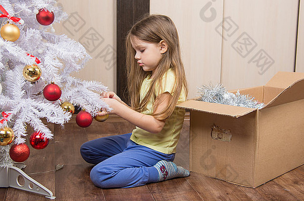 悲伤的五岁小女孩拿着一个玩具人造圣诞树