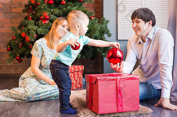 小男孩正在装饰圣诞树玩具。节日、礼物和新年概念
