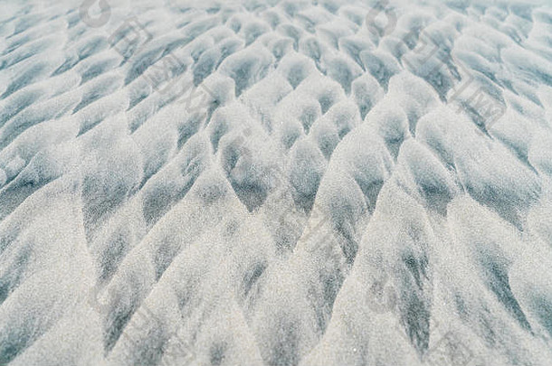 海滩上风雨引起的抽象沙纹