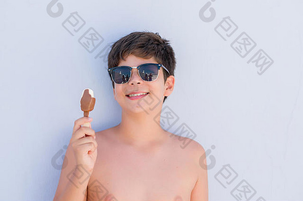 在假日吃冰激凌的小孩站着，脸上带着快乐的表情，脸上带着自信的笑容露出牙齿