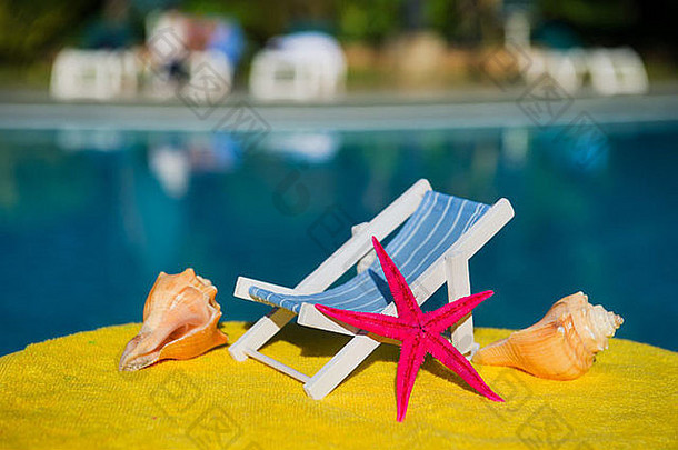 游泳池附近的沙滩椅和带星星的贝壳