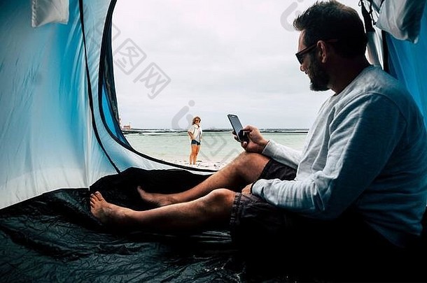 快乐的自由情侣们享受另一种免费的假日假期，他们可以在海滩上搭帐篷和露营，这是一种户外休闲活动