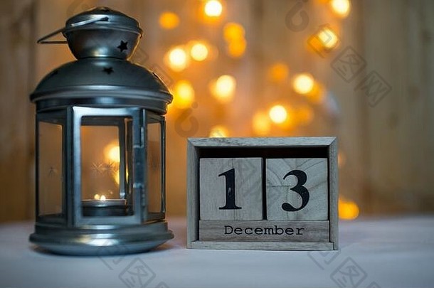 立方体木制日历，显示12月13日的日期，背景是波基的降临灯笼。降临节日历、圣诞节背景、空间