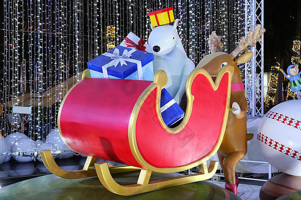有趣的户外圣诞装饰，一只驯鹿推着装满礼物的雪橇和一只北极熊