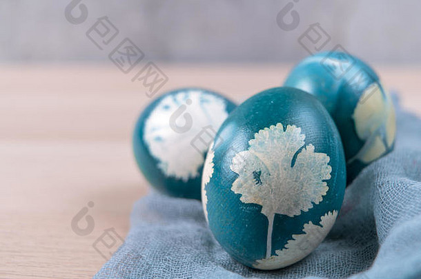 复活节快乐，三个有机的蓝色复活节彩蛋站在木桌上，复活节节日装饰，复活节概念背景与空间