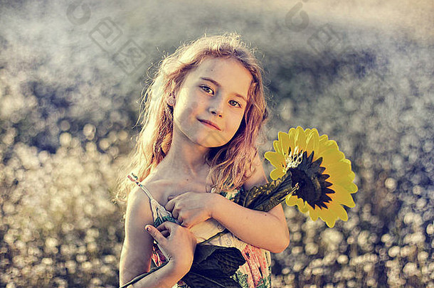 草地上抱着向日葵的女孩