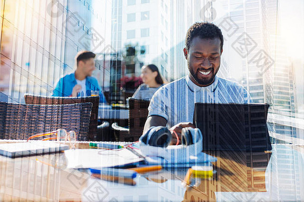 一个微笑的非裔美国人在他的平板电脑上工作