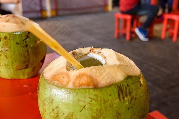 椰子顶部有一个洞和一根塑料吸管，在泰国很常见。
