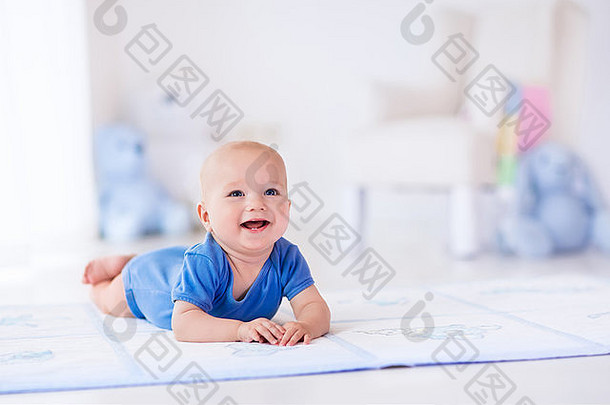 白色阳光卧室里可爱的。新生儿在地毯上休息。幼儿托儿所。
