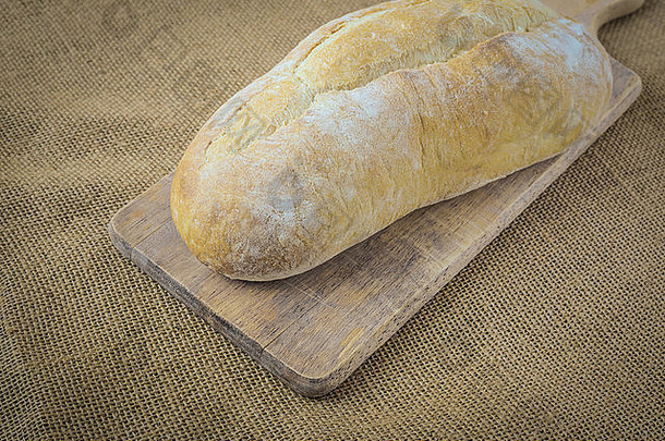 粗麻布背景面包板上的面包