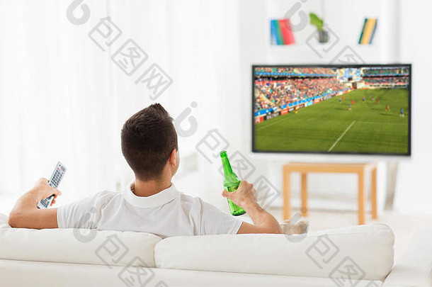 男人在电视上看足球比赛，喝啤酒