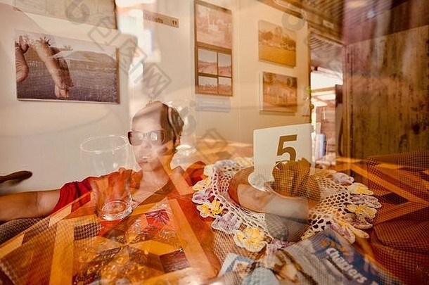 澳大利亚昆士兰汤斯维尔，一名女子坐在一家古董咖啡馆里的双重曝光