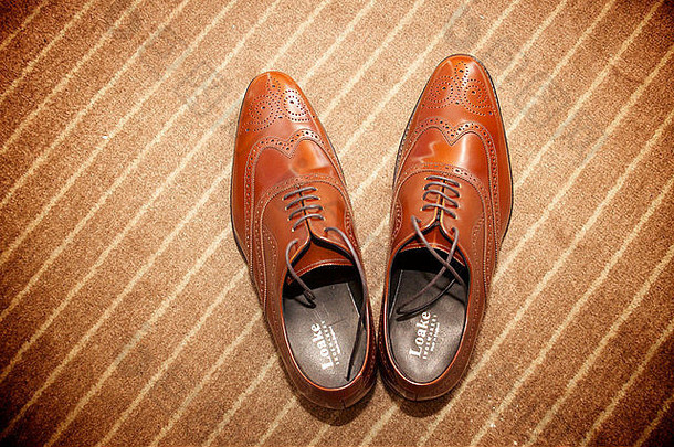 棕色地毯背景下的棕色男鞋。