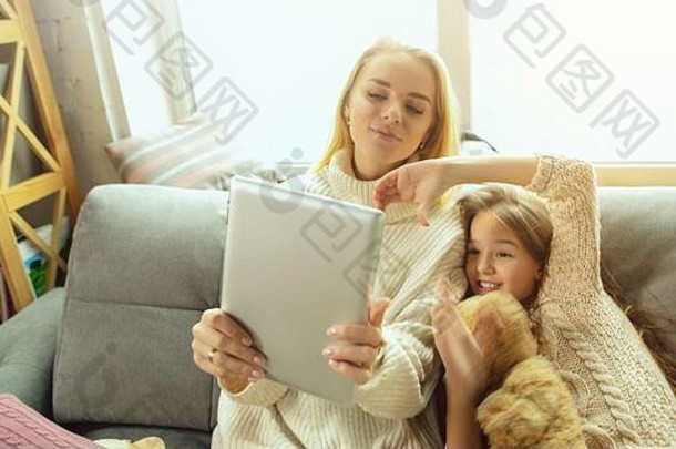 使用小工具。幸福的家庭。母亲和女儿一起在家度过时光。看电影，使用笔记本电脑，大笑。<strong>母亲节</strong>，庆祝<strong>活动</strong>，周末，节日，童年的概念。