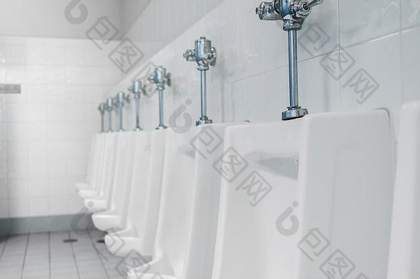 公共厕所和浴室内部有白色小便器，马桶和小便器的特写镜头，或厕所内有污渍的小便器。