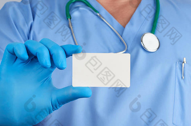医生戴着无菌乳胶手套，身穿蓝色制服，手里拿着一张空白的白色名片，上面印着联系人姓名
